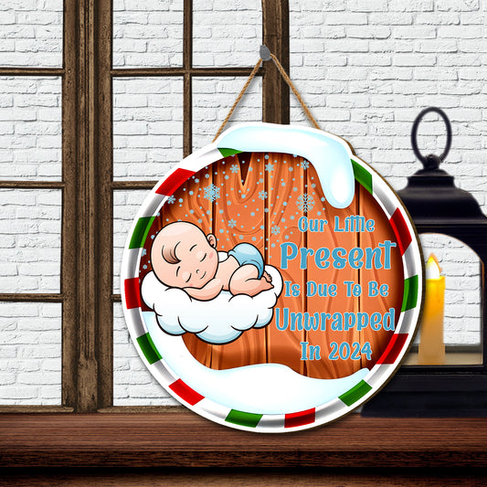 Teesdily | Christmas Round Hanging Sign, Our Little Present Is Due To Be Unwrapped In 2024 Sign, Pregnancy Christmas Door Decor, New Parents Gift Idea