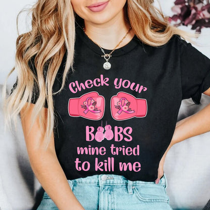 Teesdily | Check Your Boobs Mine Tries To Kill Me Shirt, Breast Cancer Sweatshirt, Cancer Awareness Pink Ribbon Hoodie Mug, Cancer Survivor Gifts