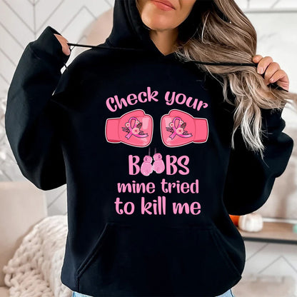 Teesdily | Check Your Boobs Mine Tries To Kill Me Shirt, Breast Cancer Sweatshirt, Cancer Awareness Pink Ribbon Hoodie Mug, Cancer Survivor Gifts